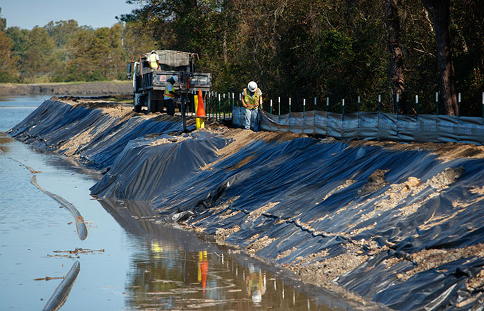 Crews with Palmetto Corp. work to shore up the banks of the Grainger Ash Pond 2 with silt fencing before river levels rise as a result of flooding caused by Hurricane Florence.