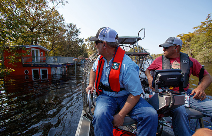 Crews with Biological Services inspect the damage already done as the  Waccamaw River over flows its banks Friday, Sept. 21, 2018 in Conway.