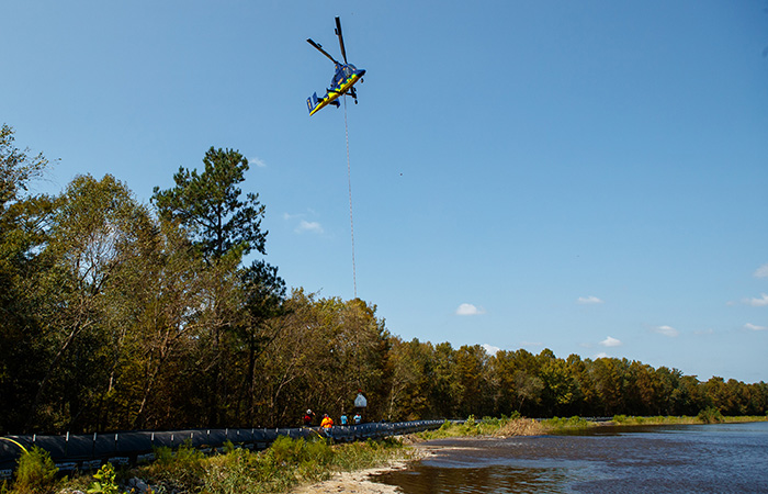 A heavy lift helicopter carries sandbags to ash pond 2 in an effort to shore up the banks of the Grainger ash ponds before river levels rise as a result of flooding caused by Hurricane Florence Friday, Sept. 21, 2018 in Conway.