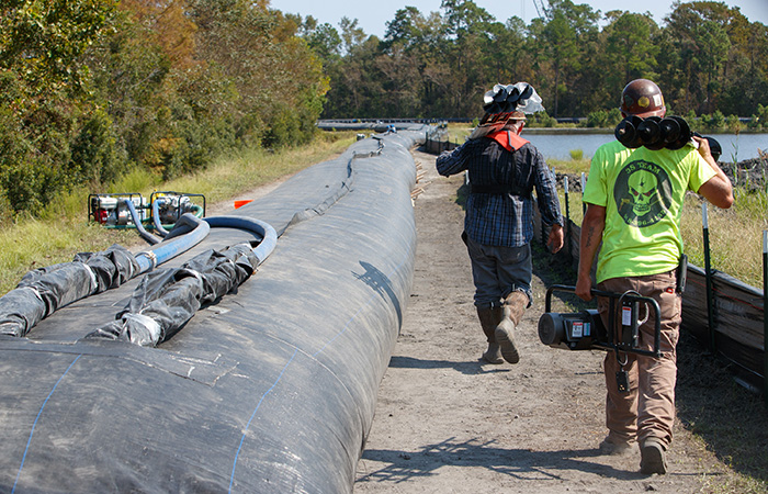 Crews finish work on an Aqua Dam surrounding ash pond 2 before river levels rise as a result of flooding caused by Hurricane Florence  Friday, Sept. 21, 2018 in Conway.