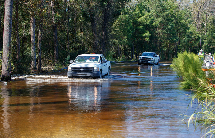 Trucks navigate the waters flooding the roads between Pond 1 and Pond 2.