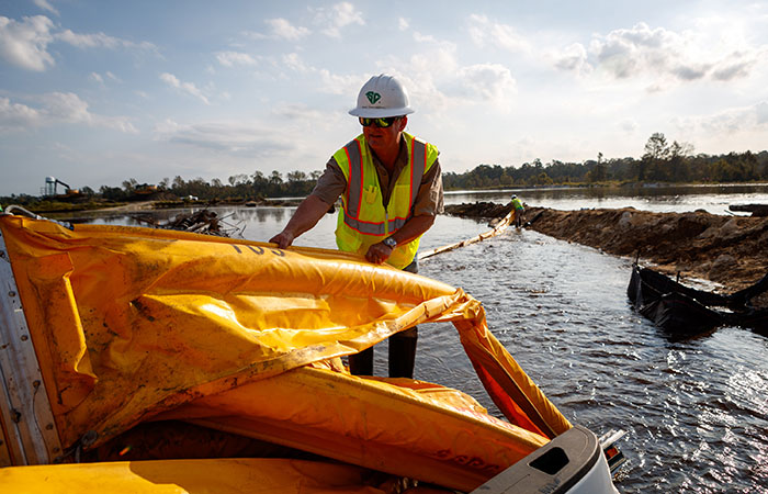 Crews deploy floating boom on Grainger Ash Pond 1 as river levels rise as a result of flooding caused by Hurricane Florence. Saturday, Sept. 22, 2018 in Conway.