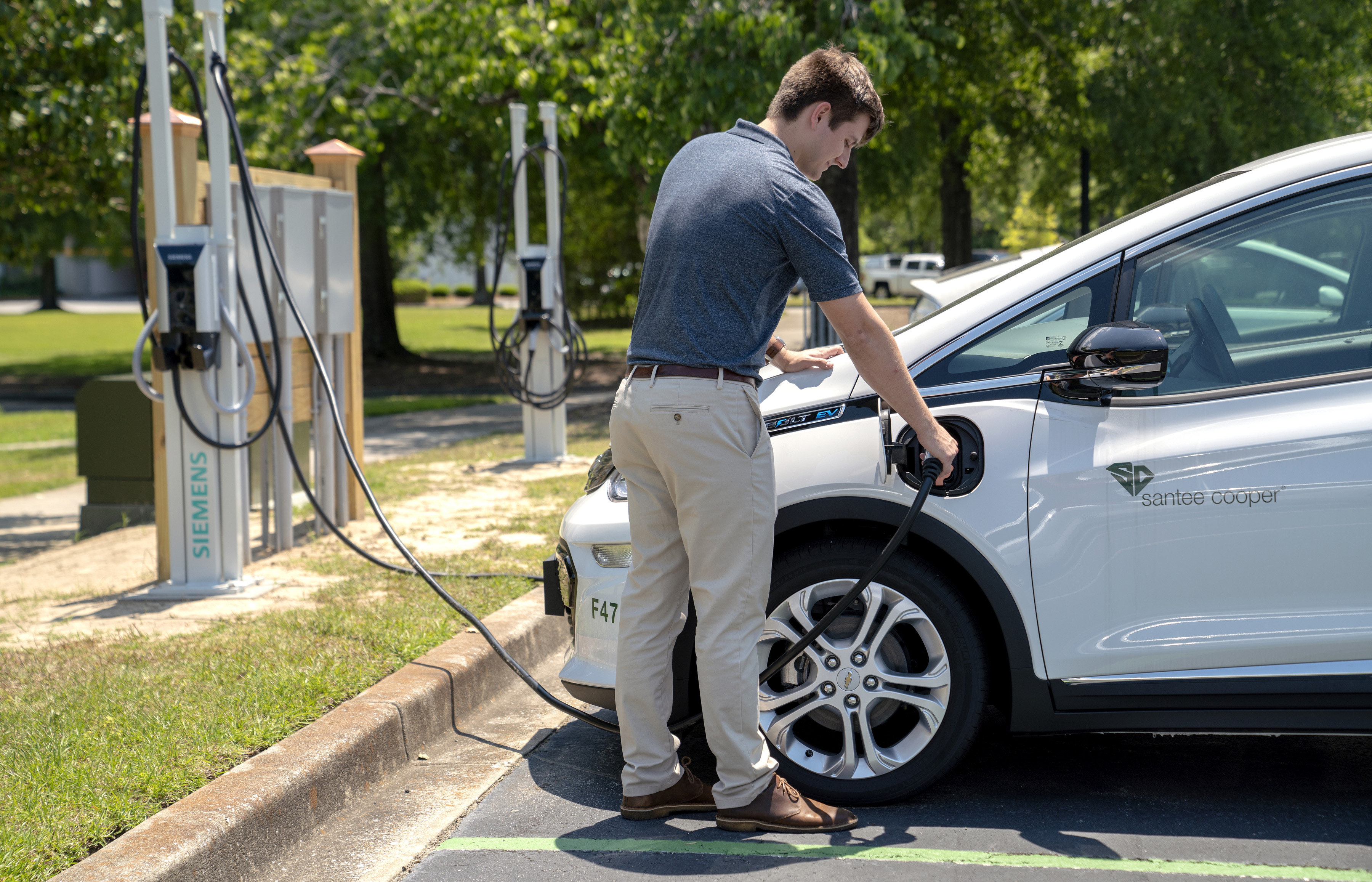 Man Charging Electric Vehicle